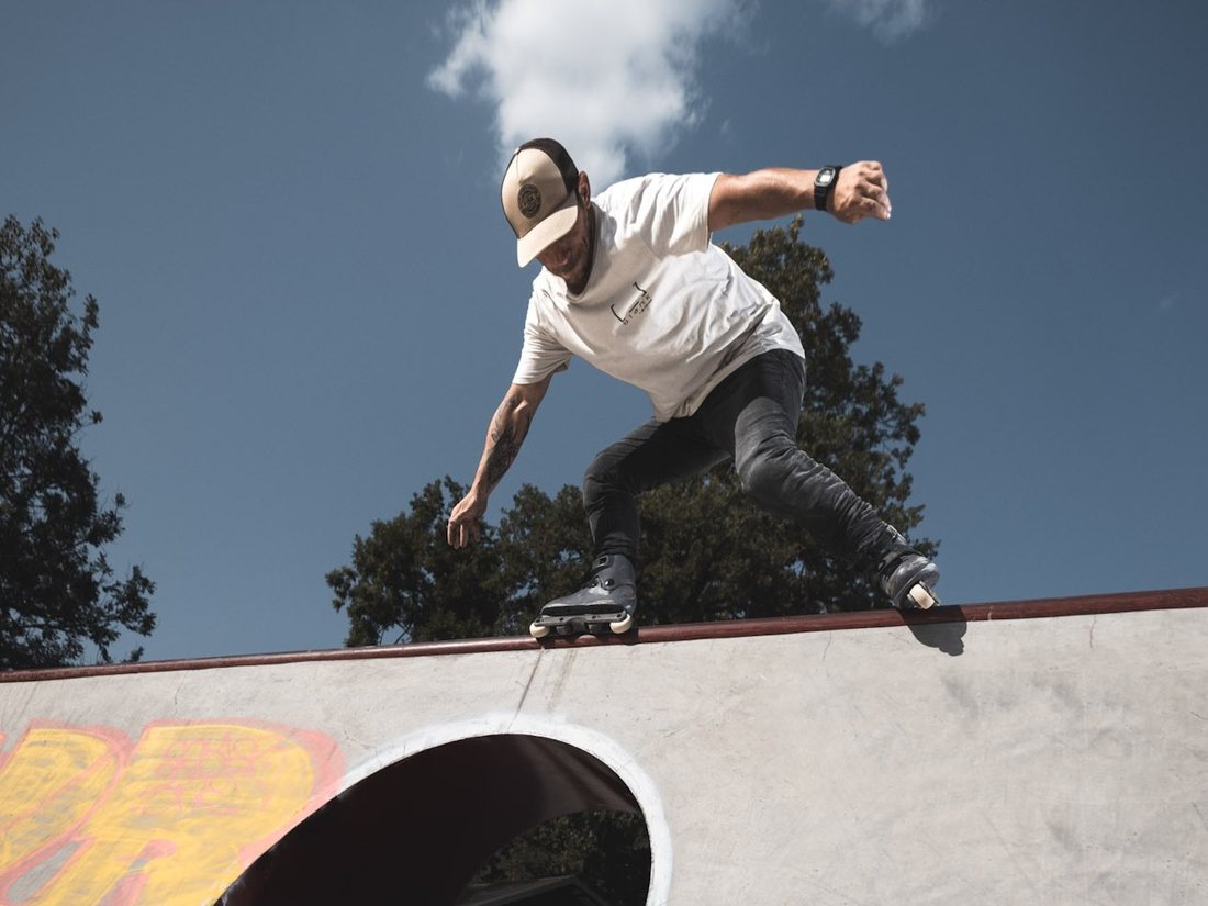 Rider en roller freestyle en équilibre sur le coping d'une rampe
