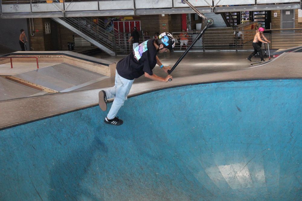 Roller freestyle dans le bowl du skatepark couvert